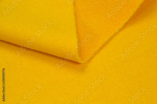 Fabric coat yellow close-up. Texture of coat fabric.