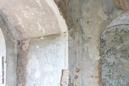 interior view of an abandoned old building with an arch in the wall