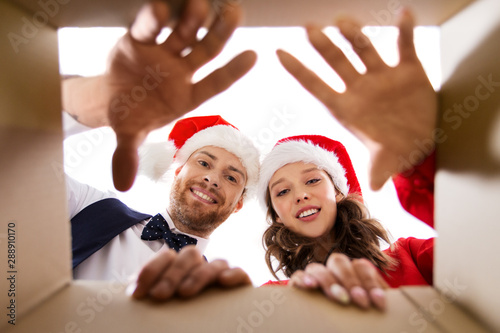 people and holidays concept - happy couple opening christmas gift box