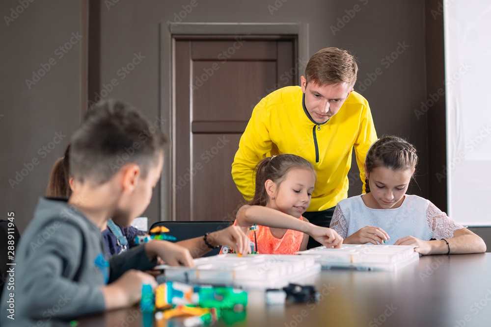 Kids creating robots with teacher. Early development, diy, innovation, modern technology concept. Kids creating robots with teacher. Early development, diy, innovation, modern technology concept.