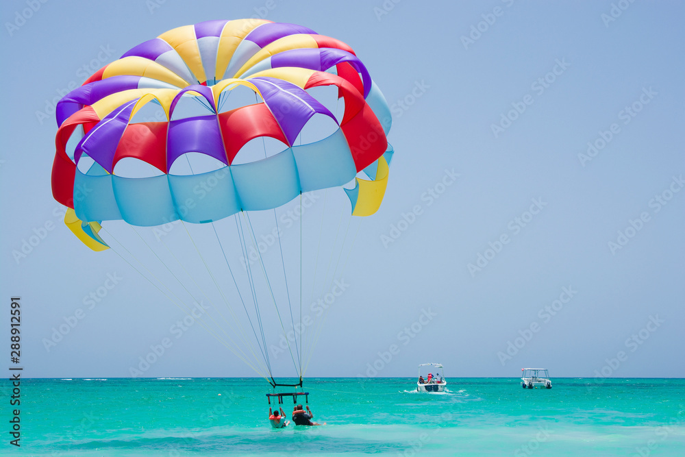 Colorful parasail wing taking off from turquoise water of Sargasso Sea, Punta Cana, Dominican Republic Colorful parasail wing taking off from turquoise water of Sargasso Sea, Punta Cana, Dominican Republic