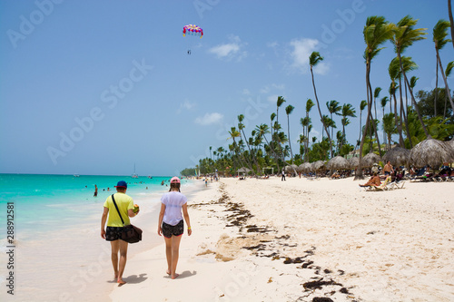Teenagers walking along san...