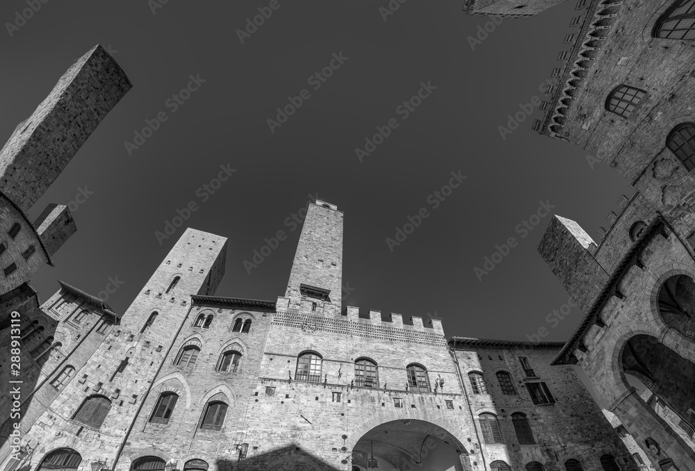 Old medeival square and towers in typical Tuscan town, popular tourist destination. Town also called  Medieval Manhattan for residential towers found therein.