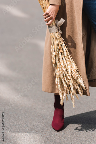 cropped view of young adult woman holding spikes outside