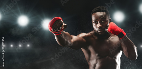 Professional black sportsman fighting on boxing arena © Prostock-studio