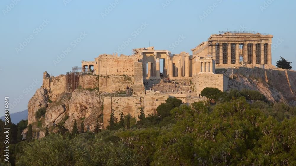 Tourists walking around the Acropolis of Athens. Icon of the hellenic civilization, Parthenon. Picturesque view of antique marble ruins on hill. Mediterranean city panorama beneath historical temple Tourists walking around the Acropolis of Athens. Icon of the hellenic civilization, Parthenon. Picturesque view of antique marble ruins on hill. Mediterranean city panorama beneath historical temple