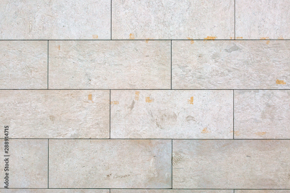 Naklejka premium Stone wall made by non uniform textured stone blocks with flat cuts and sandpapered.