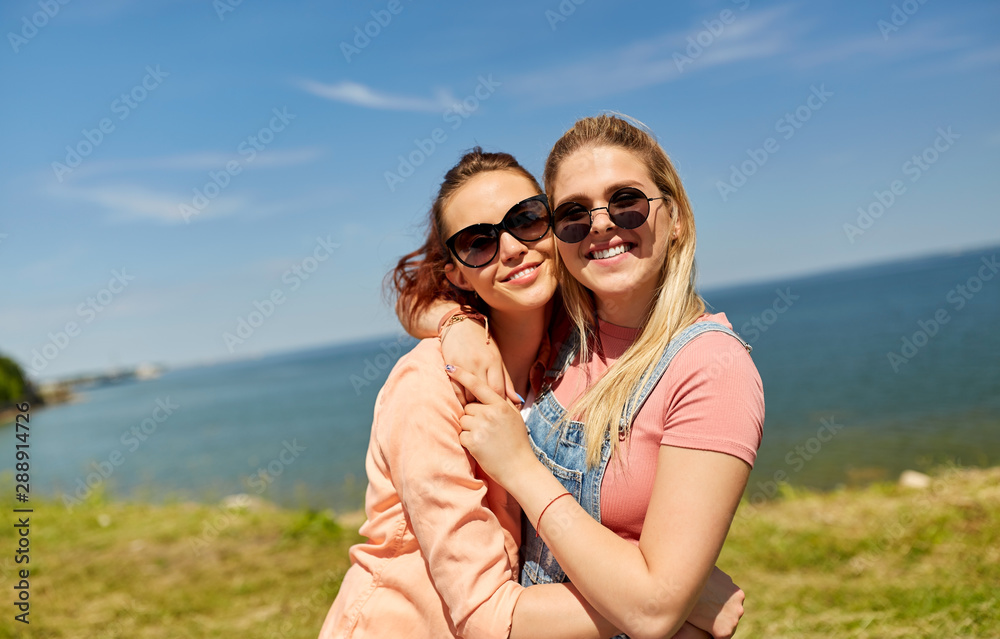 leisure and friendship concept - happy smiling teenage girls or best friends in sunglasses at seaside in summer leisure and friendship concept - happy smiling teenage girls or best friends in sunglasses at seaside in summer