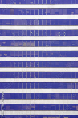 Glass blue Windows of facade modern city business building skyscraper. Modern apartment buildings in new neighborhood. Windows of a building, texture.  