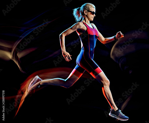 one caucasian woman triathlon triathlete runner running joogger jogging studio shot isolated on black background with light painting effect © snaptitude