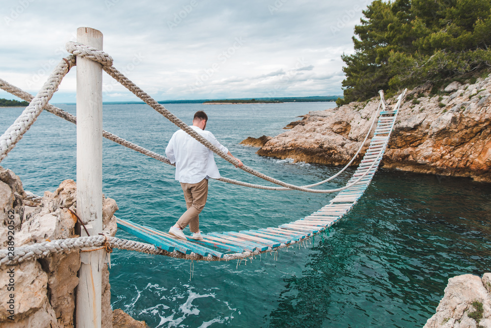 Obraz premium man walking by suspension bridge