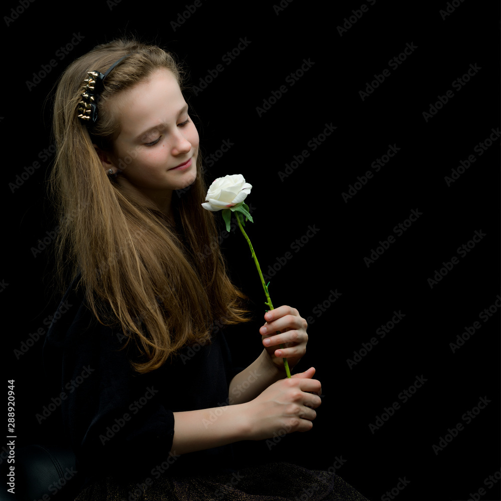 Little girl with a white flower on a black background. Little girl with a white flower on a black background.