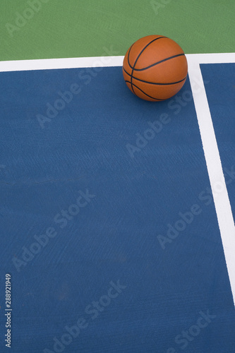 Basketball rests on court © joe