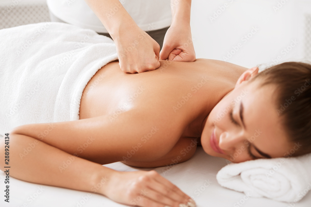 Body treatment. Girl getting back massage from physiotherapist Body treatment. Girl getting back massage from physiotherapist
