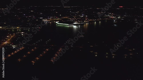 Aerial, pan, drone shot, of Helsinki north harbor, overlooking Kruununhaka, Tervasaari, Merihaka and Sompasaari, the city full of lights, on a clear summer night, in Uusimaa, Finland photo