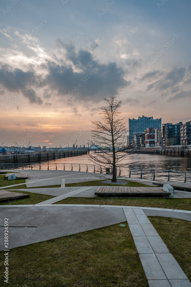 Sunset at Marco Polo Terraces in Hafencity Hamburg with bare trees and no people.