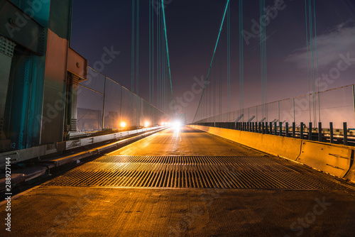 Night view of Vincent Thomas Bridge road grates and on coming headlights in Los Angeles, California.   photo