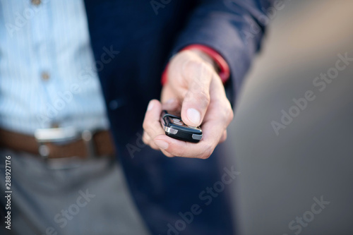 Businessman holding car keys while running late for work