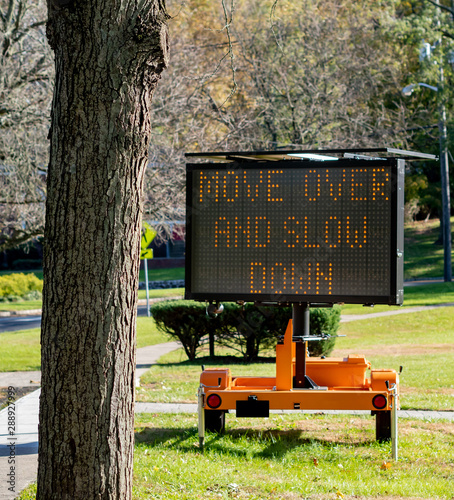 police road sign to move over and slow down