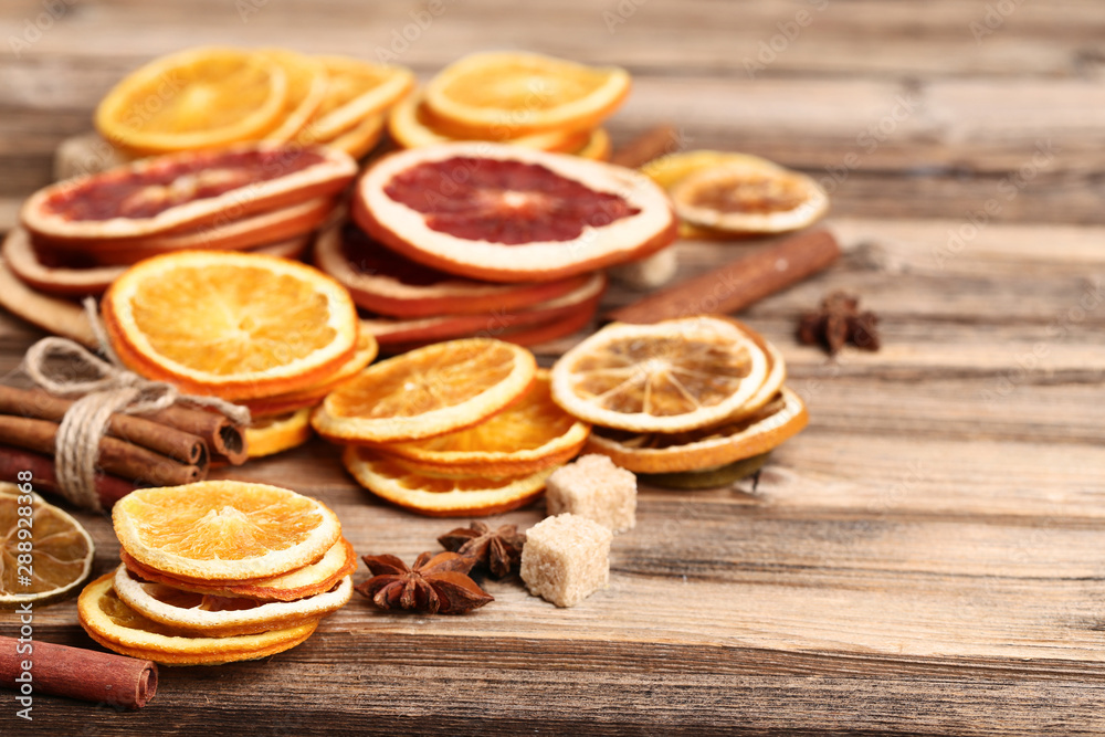 Dried citrus fruits with cinnamon, star anise and sugar cubes on brown wooden table