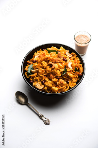 Cornflake Chivda or Corn Chiwda loaded with peanuts and Cashew. Served in a bowl. selective focus photo