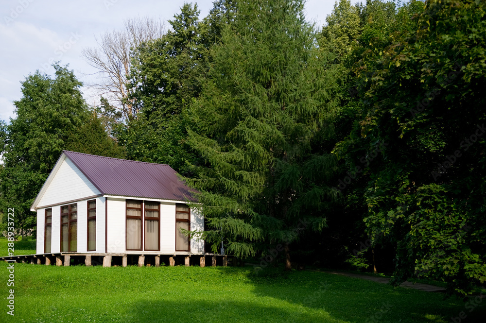 Fototapeta premium small white house with curtained windows stands on a small slope, copy space