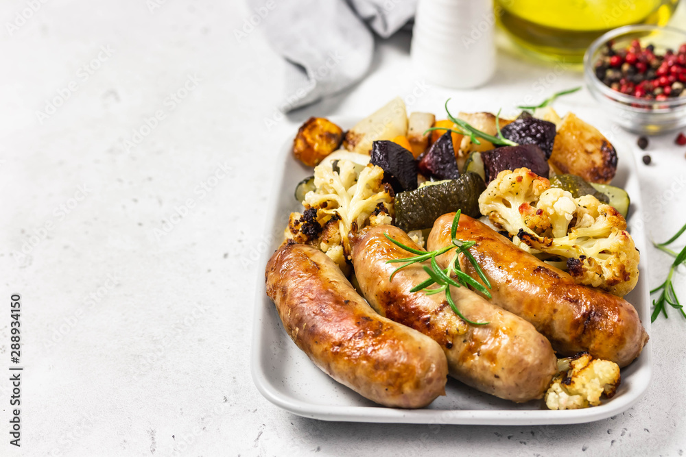 Baked vegetables and sausages. Selective focus, space for text.