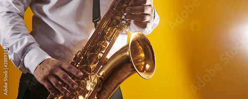 Photography Professional musician saxophonist man in  white shirt plays jazz music on saxoph