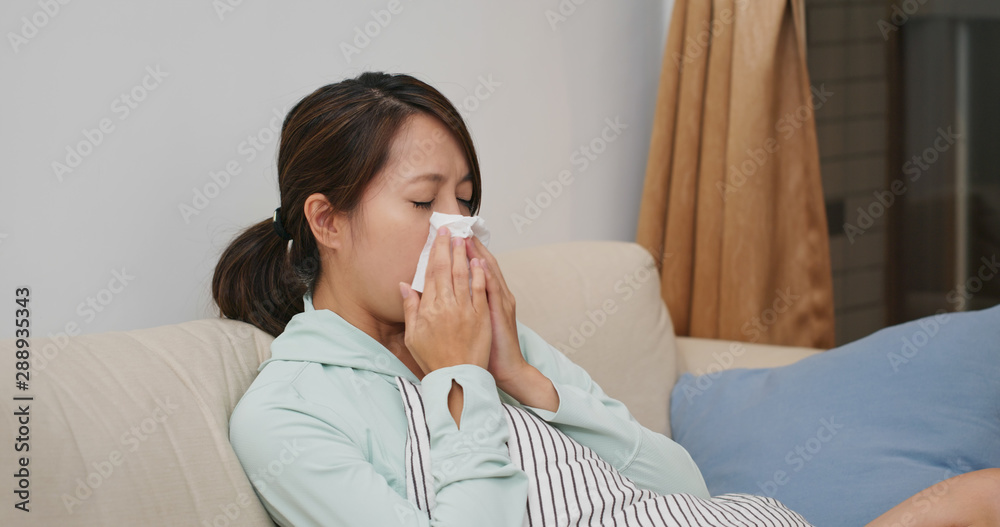 Sick woman sneeze and sit on sofa at home Sick woman sneeze and sit on sofa at home