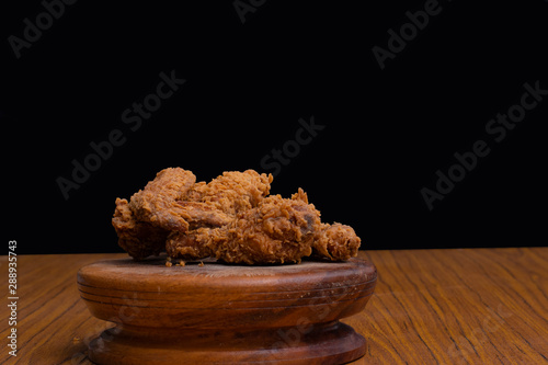 Delicious crispy fried chicken on black background