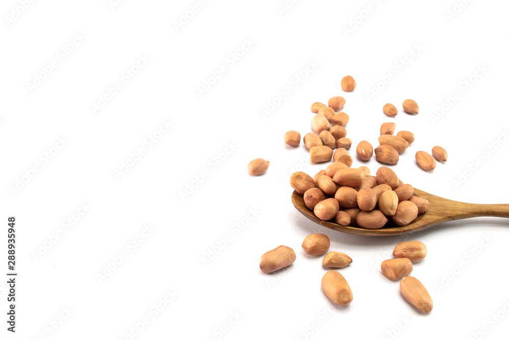 Peanuts in a wooden spoon And some are scattered isolated on a white background Peanuts in a wooden spoon And some are scattered isolated on a white background