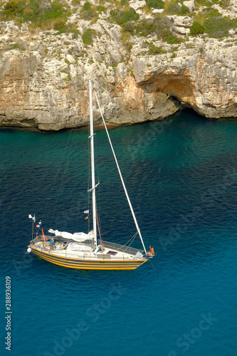 View on white boat on the beach Cala en Porter, Menorca.