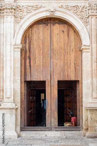 Vagabundo sentado en la puerta de la iglesia 