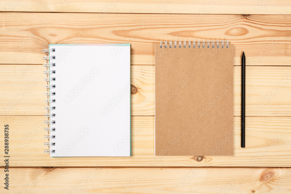 top view of a open notebook with pencil on a wooden background, school notebooks with a spiral spring, office notepad . Flat lay top view of a open notebook with pencil on a wooden background, school notebooks with a spiral spring, office notepad . Flat lay
