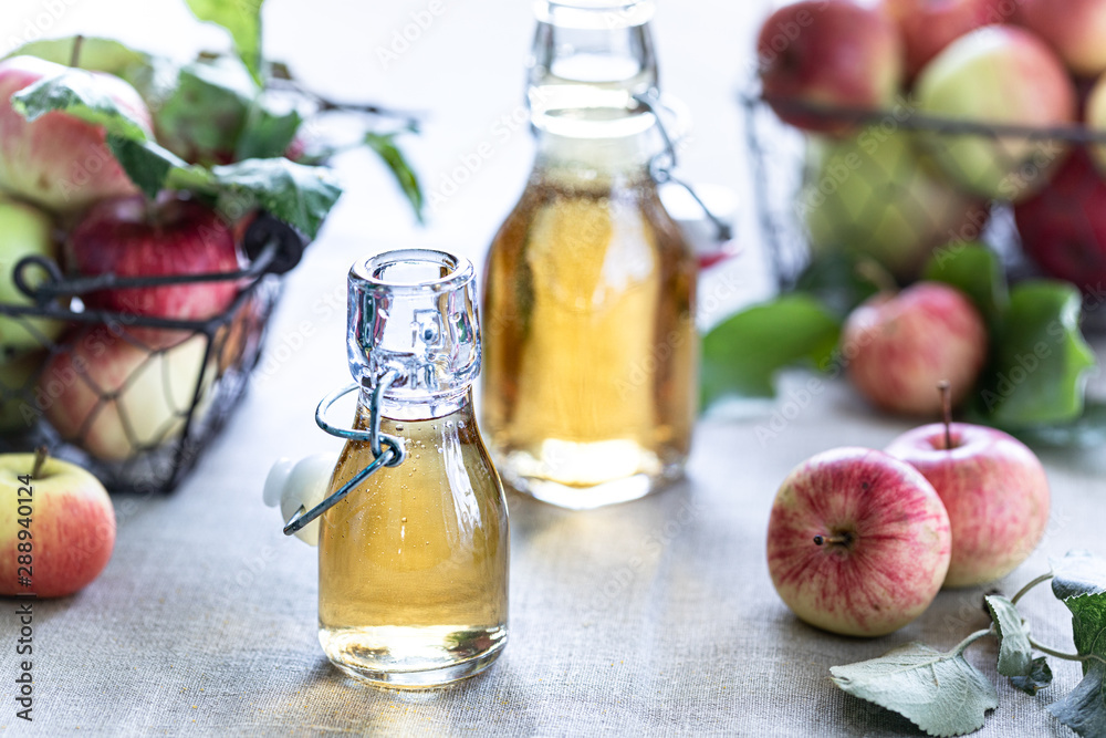Apple vinegar. Bottle of apple organic vinegar or cider on wooden background. Healthy organic food. Apple vinegar. Bottle of apple organic vinegar or cider on wooden background. Healthy organic food.