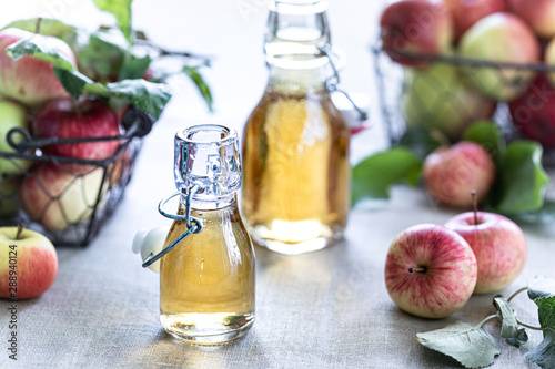 Apple vinegar. Bottle of apple organic vinegar or cider on wooden background. Healthy organic food.