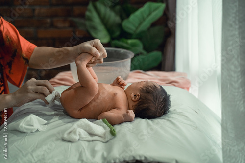 Asian little baby girl diaper replaced with a mother at home photo