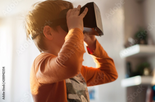 boy playes with modern virtual reality glasses photo