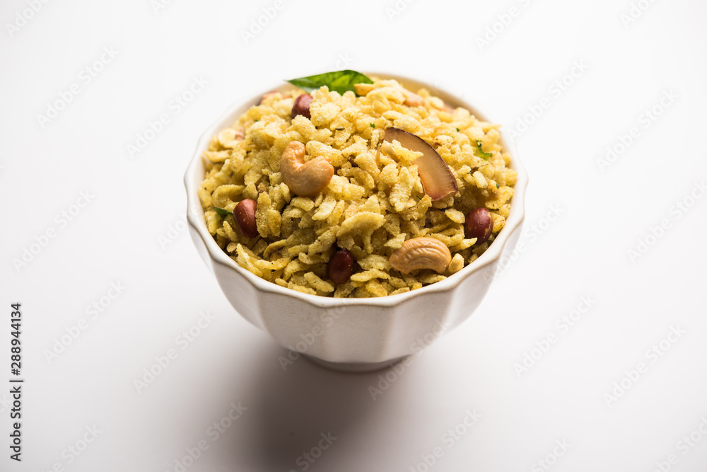 Jada Poha Namkeen Chivda / Thick Pohe Chiwda is a jar snack with a mix of sweet, salty and nuts flavours, served with tea. selective focus Jada Poha Namkeen Chivda / Thick Pohe Chiwda is a jar snack with a mix of sweet, salty and nuts flavours, served with tea. selective focus