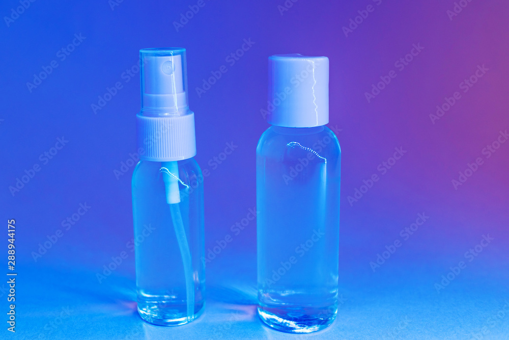Cosmetic bottles with clear lotion in trendy bright neon light. The concept of cosmetics, skin care, beauty and health. Minimalism, place for text.