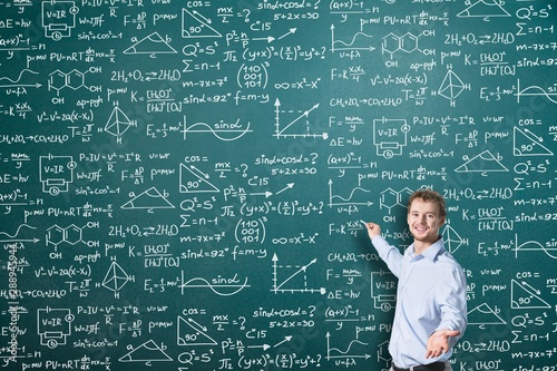 Schoolgirl writes on the blackboard formulas and mathematical equations