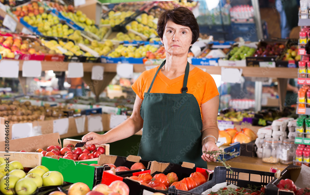 Obraz premium Portrait of adult woman seller in supermarket