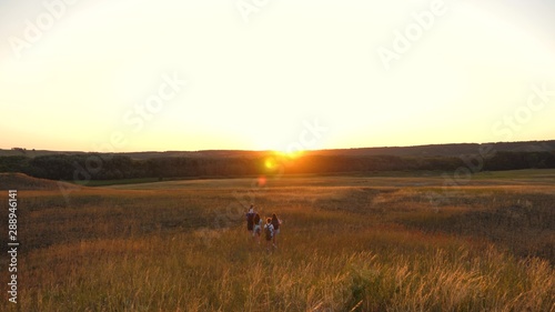 father carries a little daughter on his shoulders, a happy family travels in park. Family with children travels on the plains and mountains. father, mother daughter tourists. teamwork travelers.