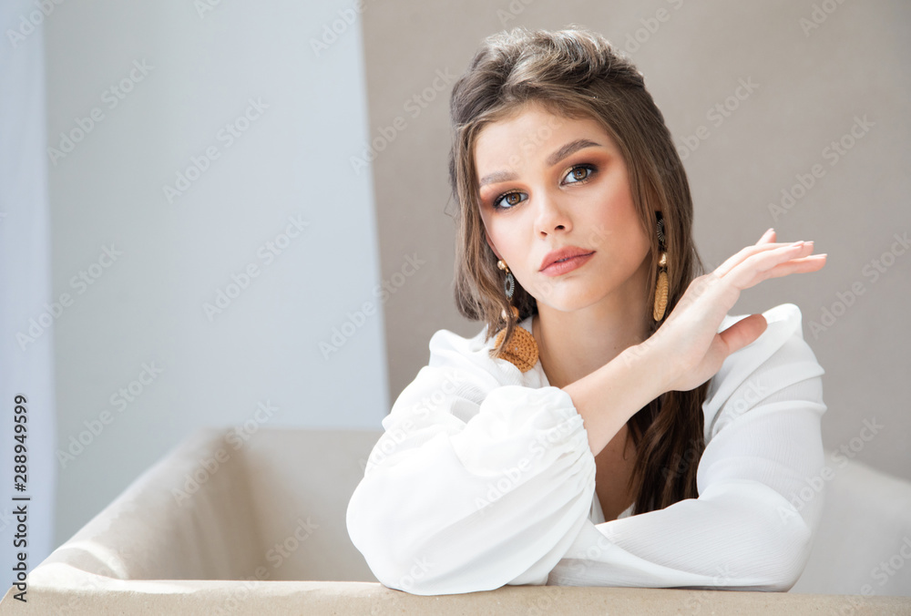 Portrait of beautiful brunette woman in white blouse sitting in a bath Portrait of beautiful brunette woman in white blouse sitting in a bath