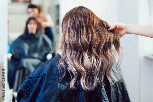 Piękna fryzura młodej kobiety po farbowaniu włosów i wykonywaniu pasemek w salonie fryzjerskim.