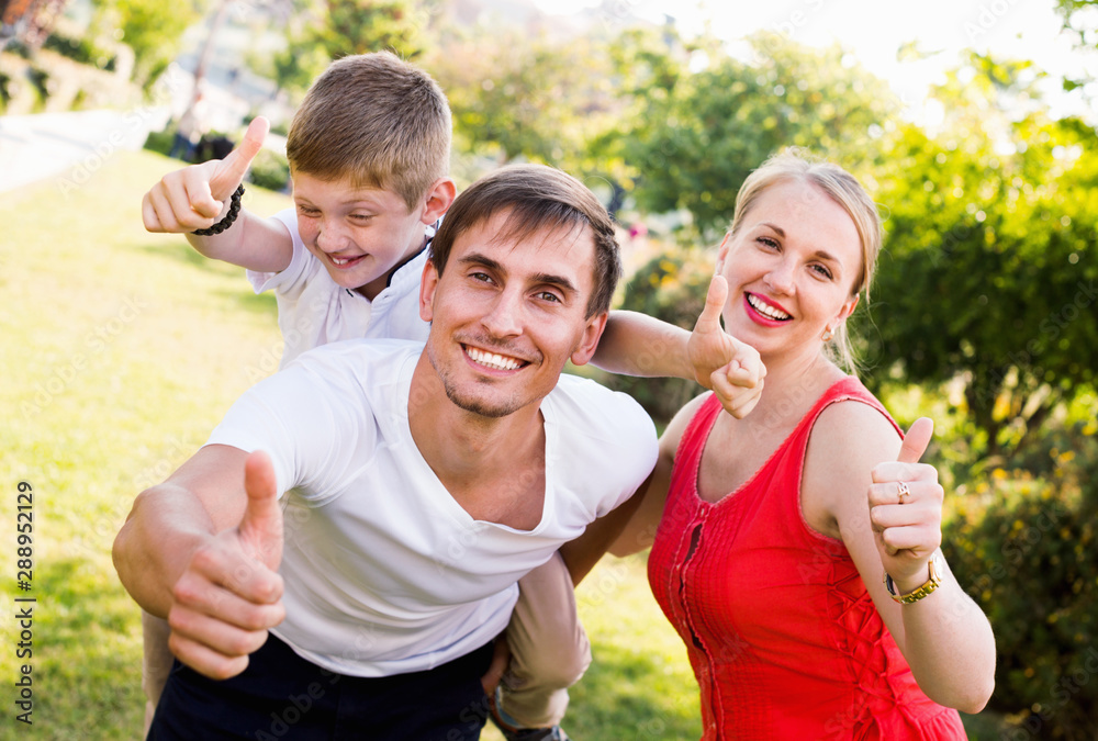 Portrait of cheerful family with boy sitting on father's back