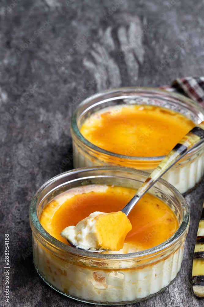 Closeup of creme brulee in glass jars on rustic wooden table Closeup of creme brulee in glass jars on rustic wooden table