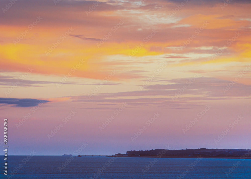 Deal Pier at dusk as a large boat passes by in the English Channel.  The image is taken the Royal Esplanade in Ramsgate, Kent, looking across Sandwich Bay.