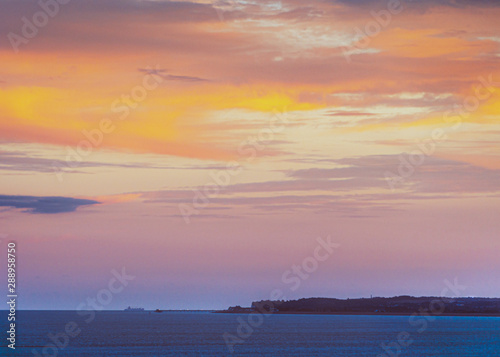 Deal Pier at dusk as a large boat passes by in the English Channel.  The image is taken the Royal Esplanade in Ramsgate, Kent, looking across Sandwich Bay.