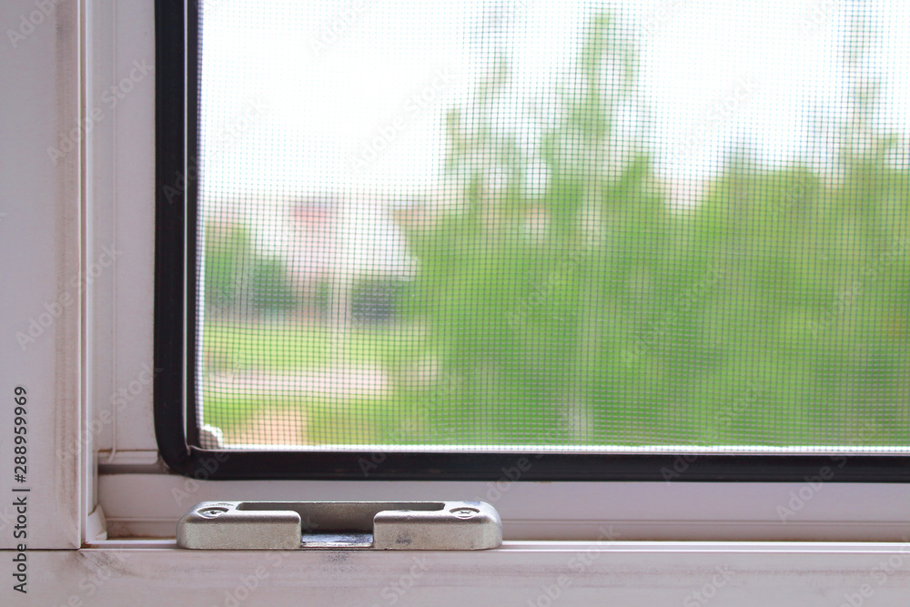 Fototapeta premium Double-glazed window and mosquito net. Close-up. View from the apartment to the street. Background. Texture.